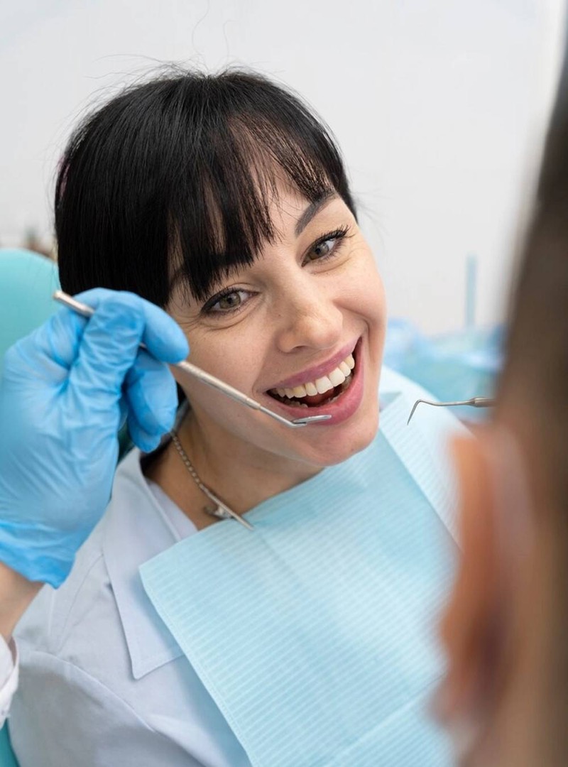 Médica dentista a acompanhar uma paciente sorridente